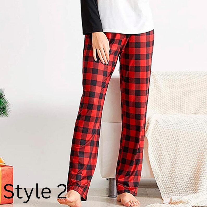May include: Red and black buffalo plaid pajama pants. The pants are part of a pajama set, with a white top and black sleeves. The text "Style 2" is visible in the bottom left corner. The pants are made of a soft, comfortable material.