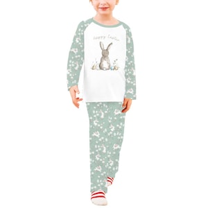 Pode incluir: Conjunto de pijama de duas pe&ccedil;as para crian&ccedil;as. A parte superior branca apresenta uma ilustra&ccedil;&atilde;o de coelho cinzento e o texto "Happy Easter". As mangas e as cal&ccedil;as s&atilde;o verde claro com um padr&atilde;o de coelhos e flores brancas.