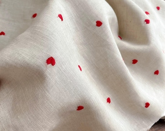 Tessuto di puro lino con ricamo a cuori rossi, adatto per abiti estivi e camicie.