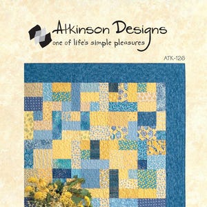 May include: A patchwork quilt with a yellow and blue color scheme. The quilt features a variety of patterned squares, including floral and geometric designs. The quilt is bordered with a solid blue fabric and has the text "YELLOW BRICK ROAD".