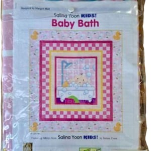 May include: A packaged quilt kit featuring a baby bath theme. The design includes a baby in a bathtub with bubbles, surrounded by pink and yellow squares. The text "Salina Yoon KIDS! Baby Bath" is visible.