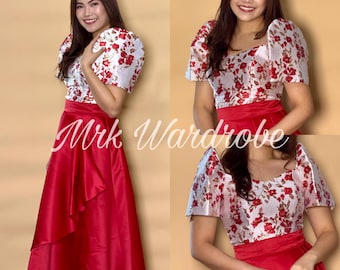 Op de afbeelding: Een rode en witte jurk met een bloemenprint. De jurk heeft een getailleerd bovenstuk en een volle rok. De rok heeft een gerimpelde zoom. De jurk wordt gedragen door een persoon met lang donker haar. De tekst "Mrk Wardrobe" is zichtbaar in de afbeelding.