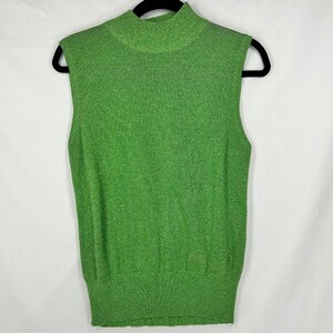 May include: A sleeveless mock neck top in a vibrant grass green color with a subtle metallic shimmer throughout the knit fabric. The garment features a ribbed collar and a wide ribbed hemline, providing a structured fit for this knit piece.