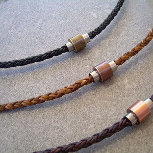 Peut inclure: Trois colliers en cuir tress&eacute; avec des accents m&eacute;talliques. Les colliers sont marron, noir et une combinaison de marron et de noir. Chaque collier a un accent m&eacute;tallique de couleur diff&eacute;rente.
