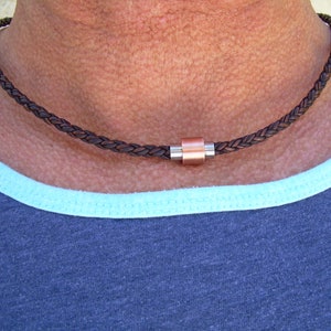 Peut inclure: Un collier en cuir tress&eacute; marron avec un fermoir magn&eacute;tique en cuivre et argent.