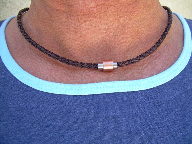 Peut inclure: Un collier en cuir tress&eacute; marron avec un fermoir magn&eacute;tique en cuivre et argent.