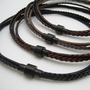 May include: Four braided leather necklaces with black metal clasps. The necklaces are in different shades of brown, black, and gray.