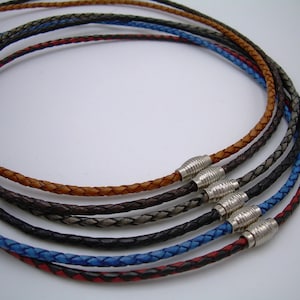 May include: Five braided leather necklaces in different colors, including brown, gray, black, blue, and red. The necklaces have silver magnetic clasps.