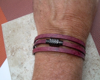 May include: A triple-wrap leather bracelet with a dark metal clasp. The bracelet is a deep burgundy colour.