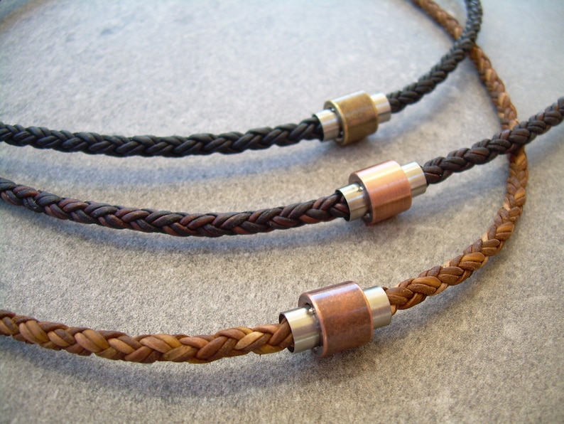 Peut inclure: Trois colliers en cuir tress&eacute; avec des accents m&eacute;talliques. Les colliers sont marron, noir et beige. Chaque collier a un accent m&eacute;tallique de couleur diff&eacute;rente.