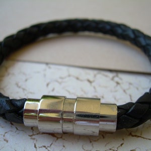 May include: A black leather braided bracelet with a silver magnetic clasp.
