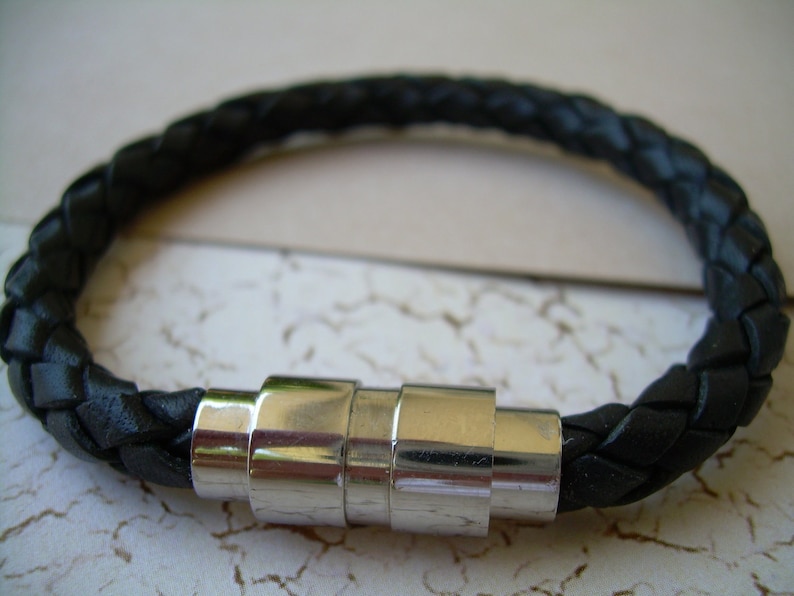 May include: A black leather braided bracelet with a silver magnetic clasp.