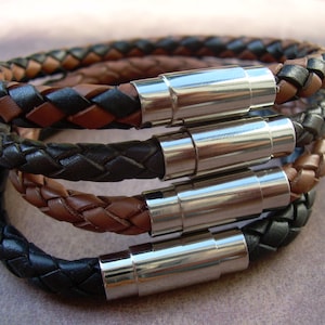 May include: A set of four braided leather bracelets with silver magnetic clasps. The bracelets are black and brown.