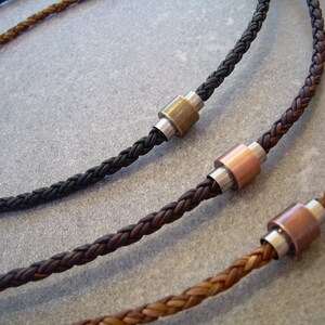 Peut inclure: Trois colliers en cuir tress&eacute; avec des accents de perles m&eacute;talliques. Les colliers sont de diff&eacute;rentes couleurs&nbsp;: marron, noir et marron clair. Les perles m&eacute;talliques sont argent&eacute;es, cuivr&eacute;es et en laiton.