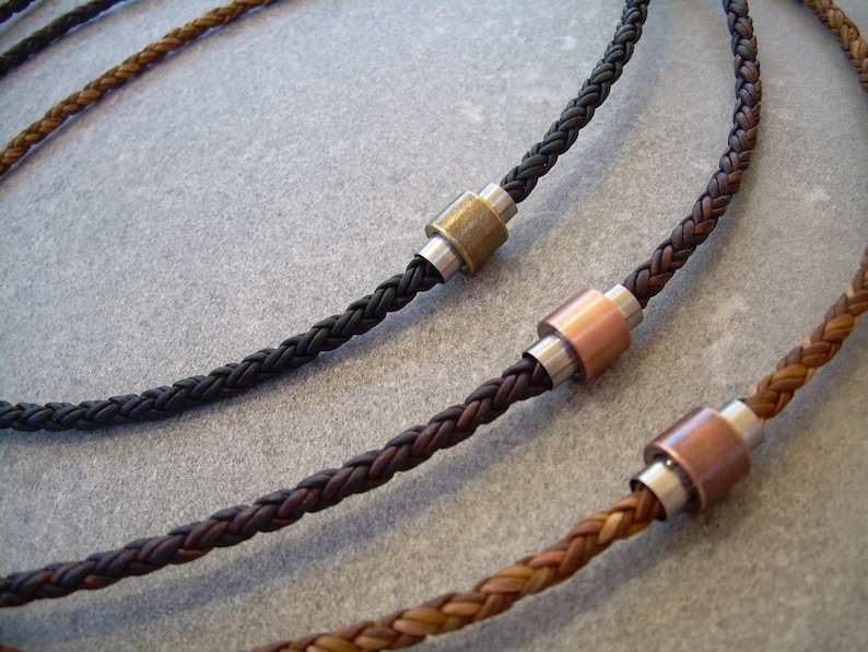 Peut inclure: Trois colliers en cuir tress&eacute; avec des accents de perles m&eacute;talliques. Les colliers sont de diff&eacute;rentes couleurs&nbsp;: marron, noir et marron clair. Les perles m&eacute;talliques sont argent&eacute;es, cuivr&eacute;es et en laiton.
