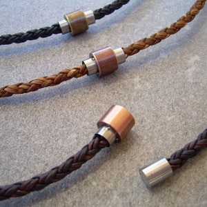 Peut inclure: Trois colliers en cuir tress&eacute; avec des fermoirs m&eacute;talliques. Les colliers sont marron, noir et une combinaison de marron et noir. Les fermoirs m&eacute;talliques sont argent&eacute;s, cuivr&eacute;s et en laiton.