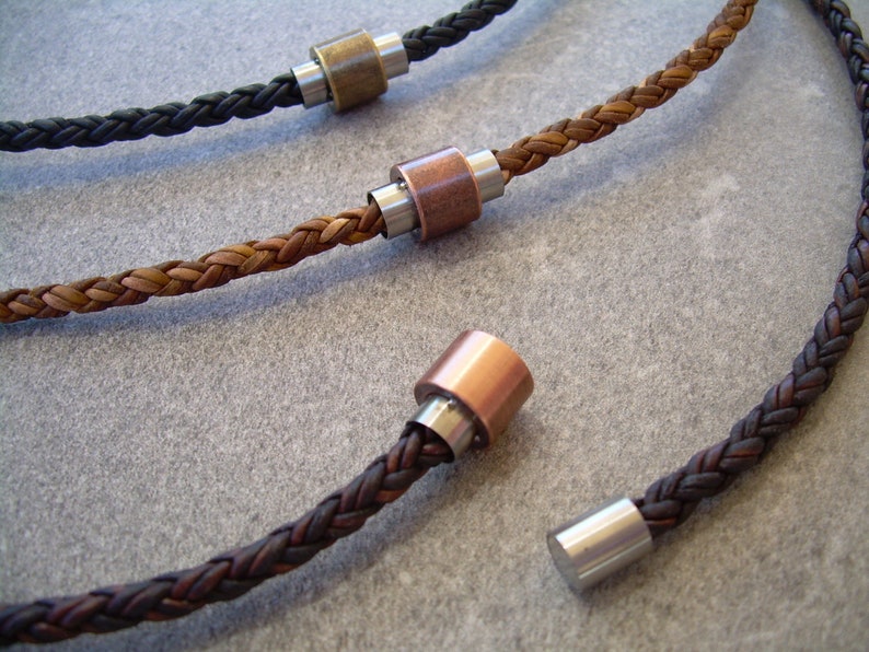 Peut inclure: Trois colliers en cuir tress&eacute; avec des fermoirs m&eacute;talliques. Les colliers sont marron, noir et une combinaison de marron et noir. Les fermoirs m&eacute;talliques sont argent&eacute;s, cuivr&eacute;s et en laiton.