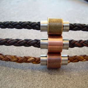 Peut inclure: Trois bracelets en cordon de cuir avec des fermoirs m&eacute;talliques. Les bracelets sont noir, marron et beige. Les fermoirs sont argent&eacute;s, en laiton et en cuivre.