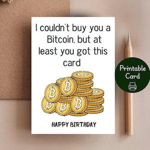 May include: A white greeting card with the text "I couldn't buy you a Bitcoin, but at least you got this card" and "Happy Birthday." The card features illustrations of gold Bitcoin coins. A pencil and a "Printable Card" sticker are also visible.