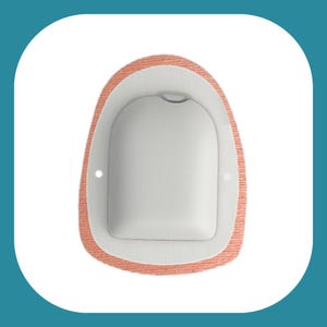 Può includere: Un adesivo medico beige e bianco con un'apertura rotonda al centro. L'adesivo è progettato per essere utilizzato con un dispositivo medico.