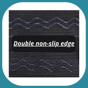 May include: Close-up of a black fabric with a double non-slip edge. The edge has a wavy pattern.