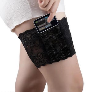 May include: Black lace thigh band with a small black electronic device tucked inside. The device has a screen displaying a graph and the text "10:20 AM 01:01:17".