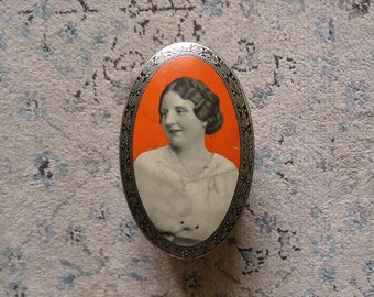 Vintage metal oval box featuring a woman portrait in orange background - tin box, collection box, boudoir, relief golden pattern, lions