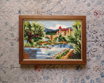 Vintage country landscape needlepoint tapestry framed in wooden frame - French village, bridge, trees and river, castle, kitch wall decor