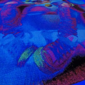 Puede incluir: Primer plano de una tela azul con un dise&ntilde;o abstracto colorido. El dise&ntilde;o presenta remolinos y formas en tonos de rosa, morado, verde y amarillo.