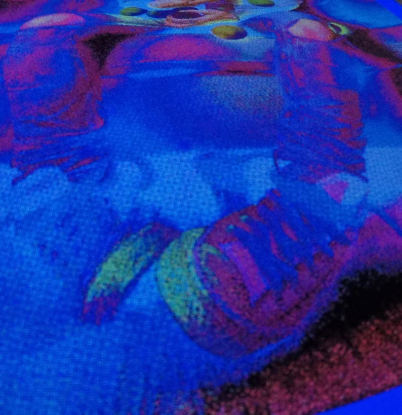 Puede incluir: Primer plano de una tela azul con un dise&ntilde;o abstracto colorido. El dise&ntilde;o presenta remolinos y formas en tonos de rosa, morado, verde y amarillo.