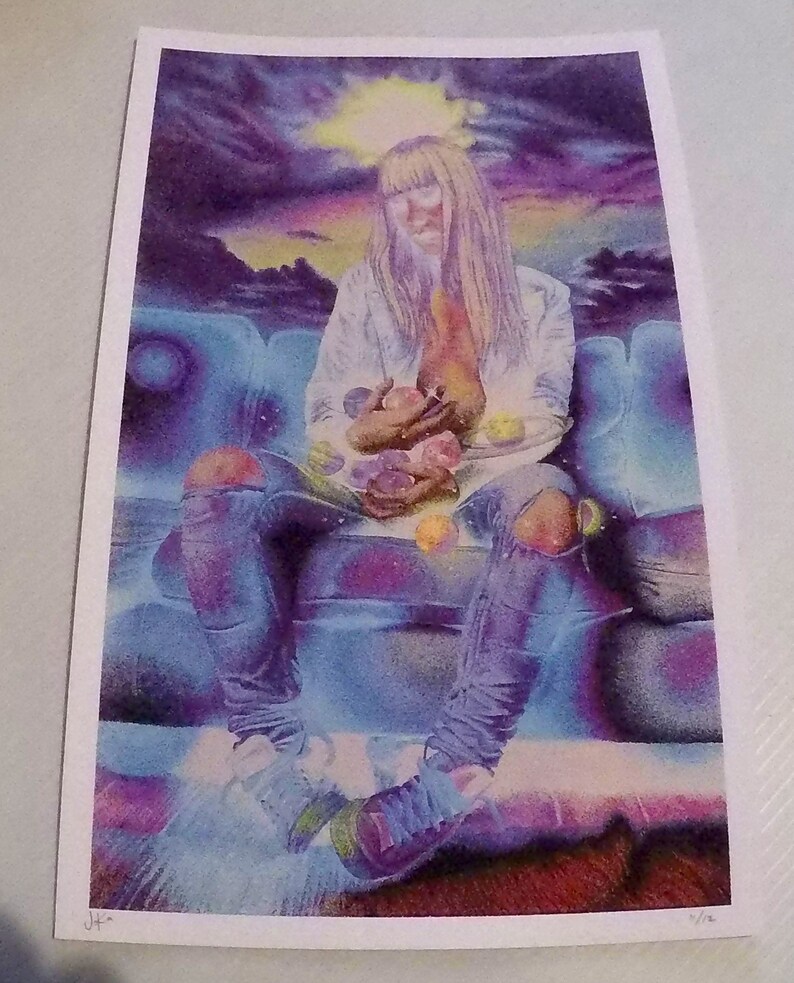 Puede incluir: Una persona con el pelo largo y rubio se sienta en un sof&aacute; azul sosteniendo un cuenco de canicas de colores. La persona lleva una camisa blanca, pantalones vaqueros azules y zapatillas deportivas. El fondo es un cielo morado y azul con un sol amarillo brillante.