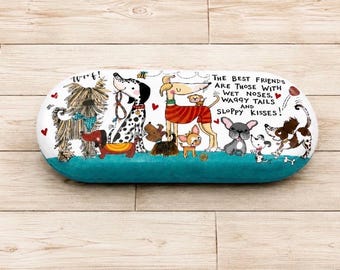 May include: An oval-shaped decorative stone featuring a colourful illustration of various dog breeds on a white background with a teal base. The text reads: The best friends are those with wet noses, waggy tails and sloppy kisses!