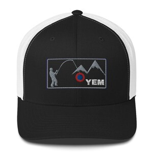 Könnte beinhalten: Schwarz-weiße Trucker-Cap mit schwarzem Schirm und weißem Mesh-Rücken. Auf der Vorderseite befindet sich ein gesticktes Patch mit einem Angler, Bergen und den Buchstaben "YEM". Der Patch enthält einen rot-blauen Kreis.