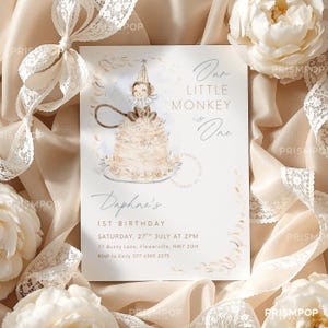 Op de afbeelding: Een crèmekleurige uitnodigingskaart met de tekst "Our Little Monkey is One" en "Daphne's 1st Birthday". De kaart toont een aquarel illustratie van een aap op een taart. De kaart is omgeven door crèmekleurige bloemen en kant.