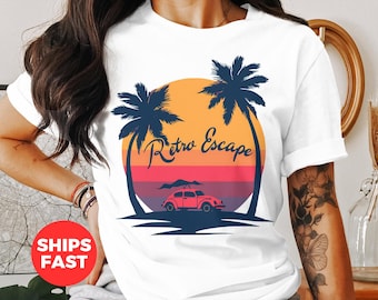 May include: White t-shirt featuring a retro design with a sunset, palm trees, and a vintage car. The words "Retro Escape" are written in a stylized font. The design uses shades of orange, pink, and blue.