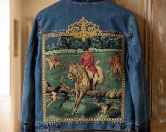 May include: A blue denim jacket featuring a large rectangular tapestry panel on the back depicting a fox hunt scene with riders on horses and hounds. The jacket has a plaid collar and cuffs in navy, green, and red, with gold embroidery.