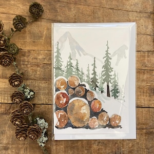 Carte de Noël aquarelle peinte à la main, de tas de bûches recouvert de neige