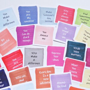 May include: A collection of square paper cards featuring watercolor-style backgrounds in various colors, each printed with motivational phrases such as You Make A difference, You Are My sunshine, You Can do Hard things, and YOUR Voice matters.