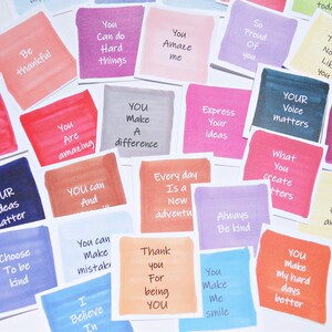 May include: A collection of square cards featuring watercolor-style backgrounds in various colors, each printed with motivational phrases such as Be thankful, You can do hard things, You amaze me, So proud of you, Your voice matters, and Choose to be kind.