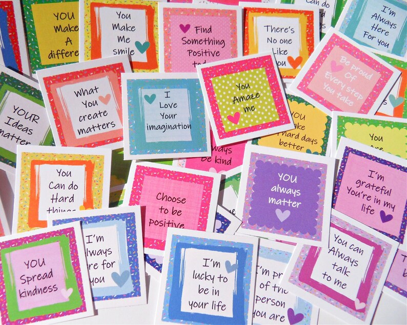 Puede incluir: Una colecci&oacute;n de tarjetas cuadradas de colores con mensajes inspiradores y corazones. Las tarjetas tienen una variedad de fondos, incluyendo lunares, chispas y rayas. Algunos de los mensajes incluyen "Haces la diferencia", "Me sorprendes", "Siempre estoy aqu&iacute; para ti", y "Siempre importas".