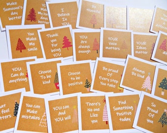 Könnte beinhalten: Eine Sammlung quadratischer Karten mit inspirierenden Botschaften und Illustrationen von Weihnachtsbäumen. Die Karten haben einen braunen Hintergrund mit weißem Text und sind auf einer weißen Oberfläche angeordnet. Botschaften sind "You Make Me Smile" und "Choose to be kind."
