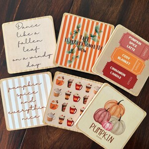 Könnte beinhalten: Eine Sammlung von sechs quadratischen Untersetzern mit herbstlichen Designs. Die Untersetzer zeigen Sätze wie "Pumpkin Spice Latte" und "Fall is my personality now". Weitere Designs sind Kürbisse und Kaffeetassen. Die Untersetzer sind aus hellem Material.