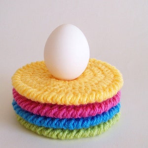 Round crochet coasters made with colorful worsted weight yarn, displayed on a white background. Easy, beginner-friendly crochet pattern for double-thick crochet coasters.