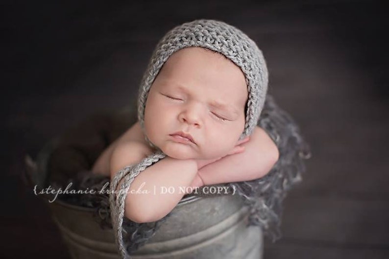 Beginner knitting pattern for a classic newborn bonnet hat. Quick and easy knitting project for a baby accessory and a photo prop.