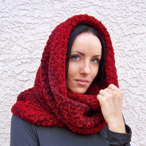 Puede incluir: Un cuello de lana rojo con una superficie texturizada y peluda. El cuello es usado por una persona con cabello largo y oscuro.