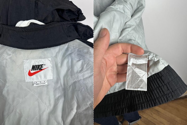 May include: Black Nike windbreaker jacket with a white lining and a Nike logo on the left chest. The jacket has a zipper closure and a hood. The tag says "Nike" and "Made in Taiwan".