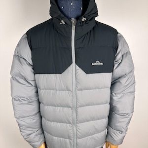 Puede incluir: Chaqueta acolchada con capucha en gris y negro. Cuenta con cremallera completa, cuello alto y el logo "Kathmandu" en el pecho. Dise&ntilde;ada para el fr&iacute;o, esta chaqueta es ideal para actividades al aire libre.