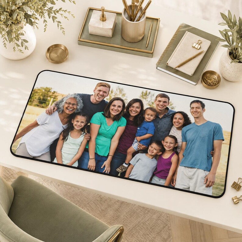 May include: A rectangular desk mat featuring a printed photograph of a large multi-generational family posing together outdoors. The family members are wearing casual clothing in various colors, including white, green, blue, and purple shirts.