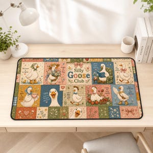 May include: A rectangular desk mat featuring a patchwork design of various illustrations of white geese. The central panel reads Silly Goose Club. The geese are depicted in different outfits and activities, surrounded by floral and checkered patterns.