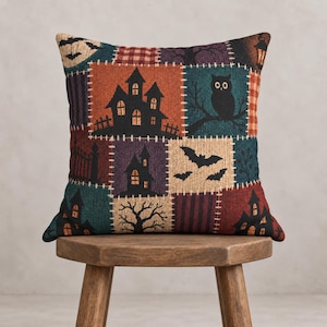 Könnte beinhalten: Ein quadratisches Zierkissen mit Patchwork-Design und verschiedenen Halloween-Motiven, darunter schwarze Silhouetten von Spukhäusern, eine Eule auf einem Ast, fliegende Fledermäuse, kahle Bäume und eine leuchtende Laterne auf dunklem Hintergrund.